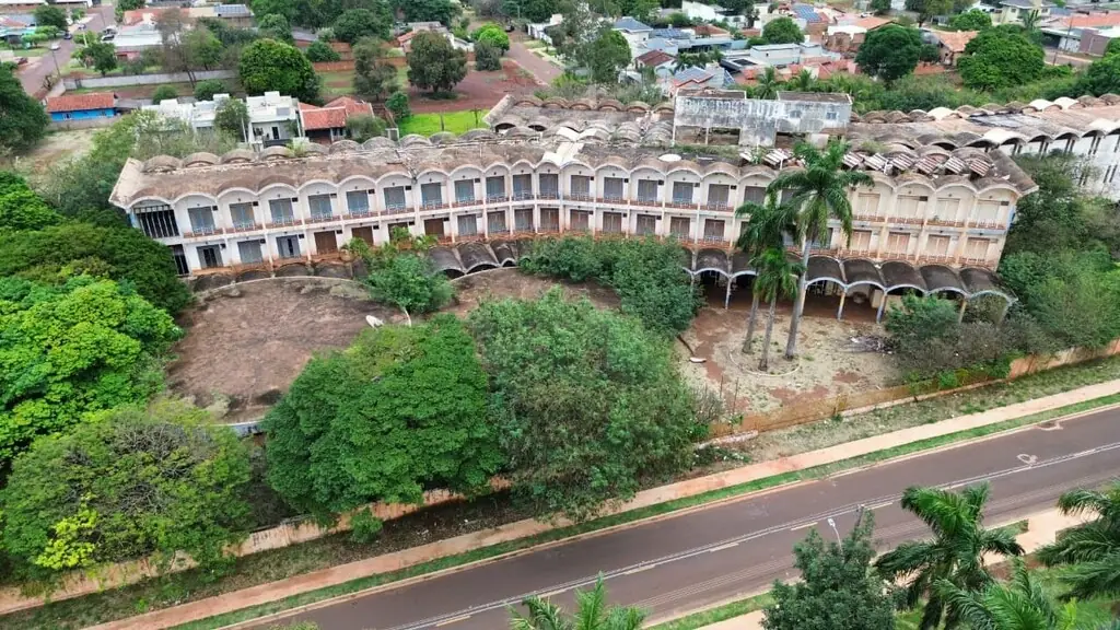 Vista aérea do Dourados Park Hotel mostrando a fachada curva com a fileira de arcos e o pátio interno tomado pela vegetação