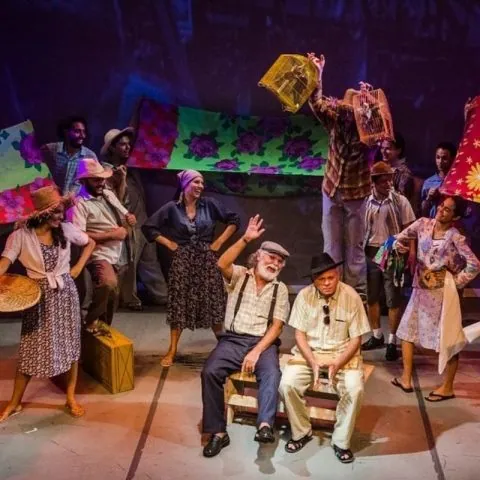 Apresentação de dança folclórica com figurinos coloridos, no palco