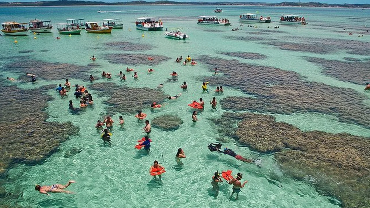 Piscinas naturais de água clara com pessoas em pé sobre os bancos de areia