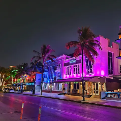 Rua de Miami à noite, com letreiros de neon coloridos