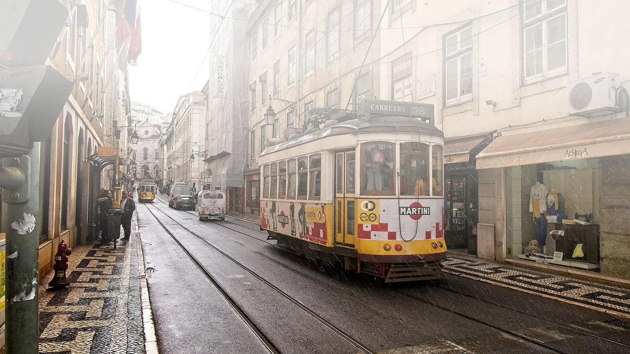 Bonde amarelo em rua estreita de Lisboa, com fachadas antigas dos dois lados
