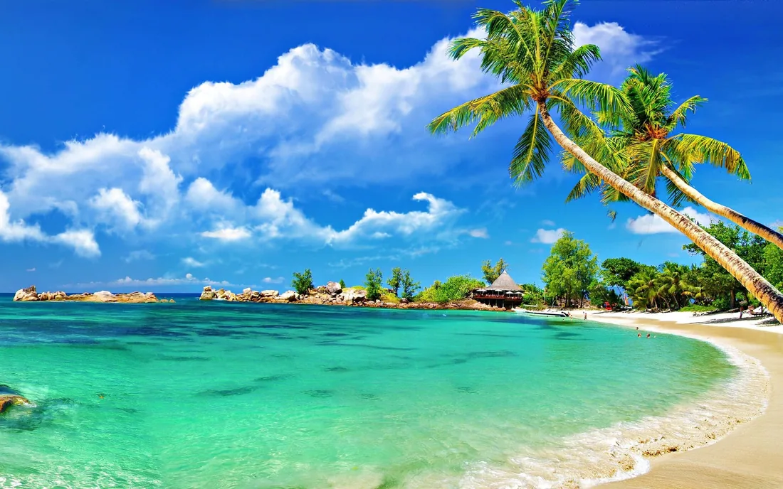 Praia larga com mar azul e céu limpo