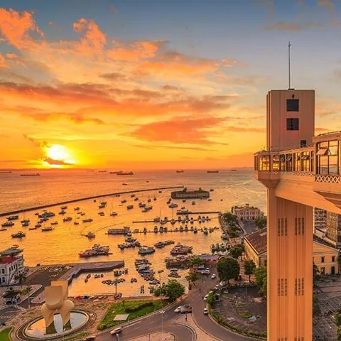 Orla de Salvador ao pôr do sol, com o farol e o mar